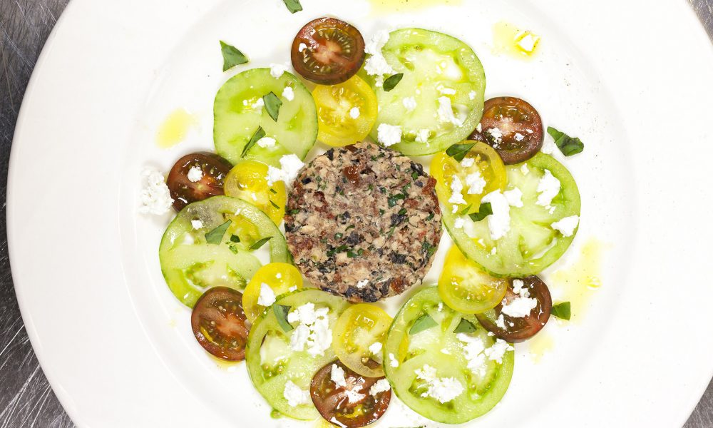 Un tartare frais de sardines sur un lit coloré de tomates