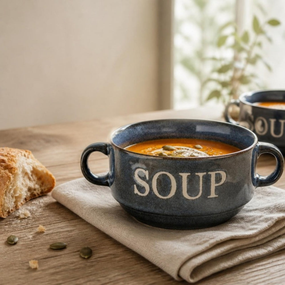 Blauwe soepkom Soup met pompoensoep op een houten tafel bij het raam
