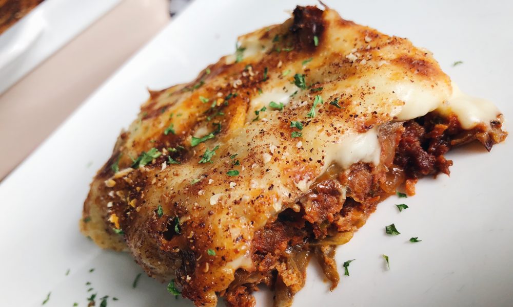 Un gratin grec classique avec des aubergines, de la viande hachée épicée et une onctueuse sauce béchamel