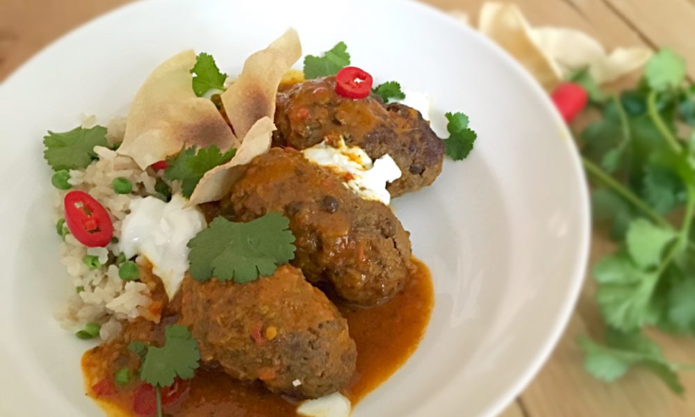 Boulettes de viande juteuses dans une sauce crémeuse curry-coco avec riz aux herbes